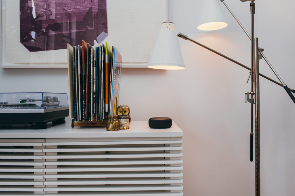 An Echo dot with smart lights shining on it.