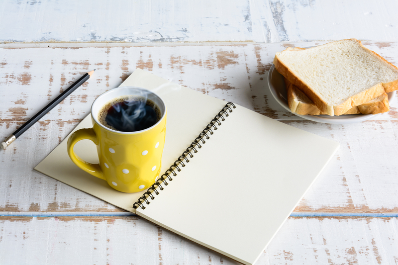 Morning coffee and toast with open notebook.