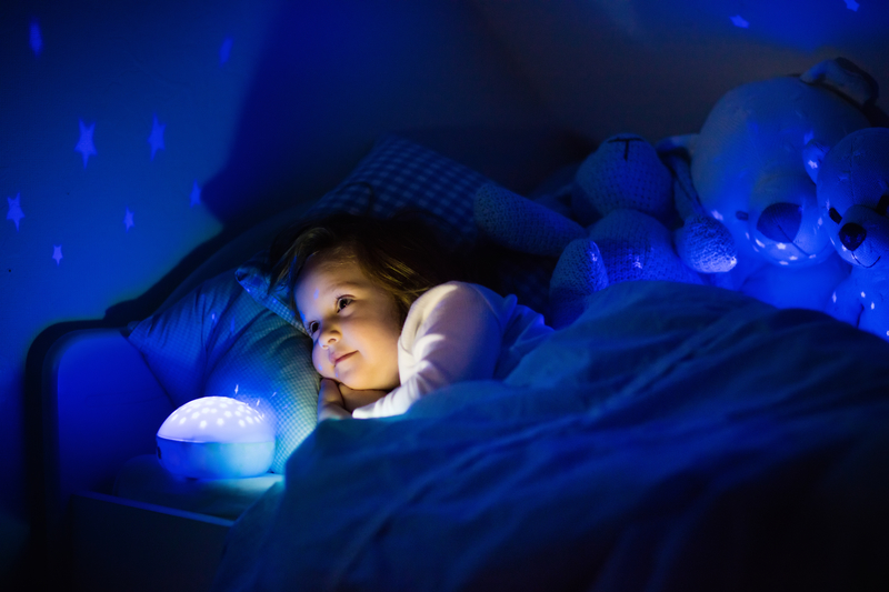 Girl in bed with star night light.